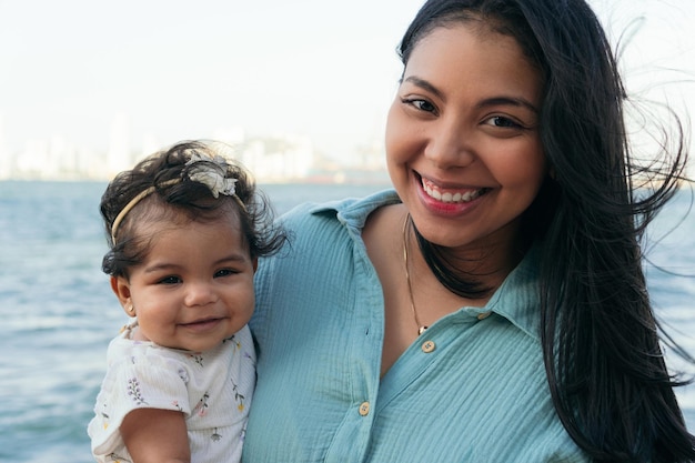 Latin woman stands with her baby in the park