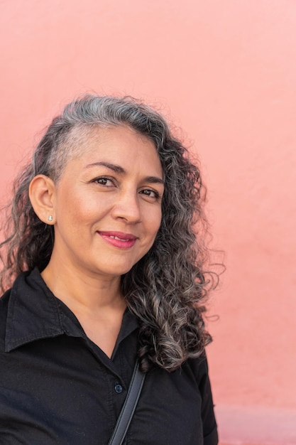 Latin woman with gray hair smiling in the street