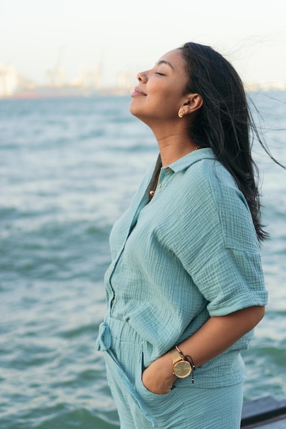 Latin woman with her eyes closed while standing in park