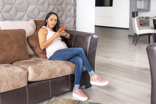 Latin woman with straight black hair looking at her cell phone