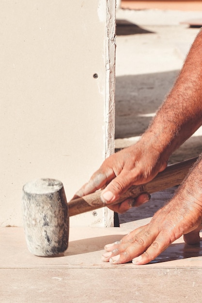 latin worker laying tile, tool in hand, background,