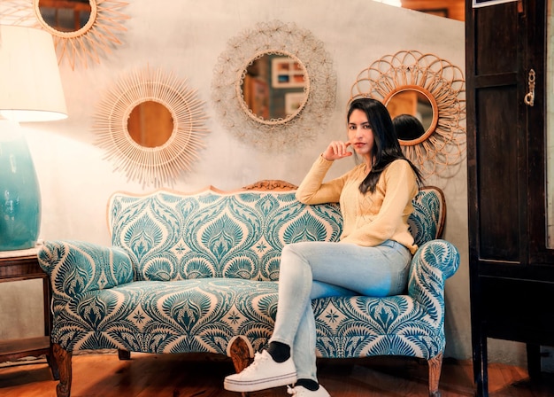 Latin young woman sitting on sofa indoors portraitx9