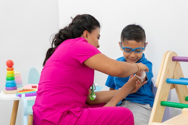 Latina pediatrician doctor taking measurement of a child's arm in her office