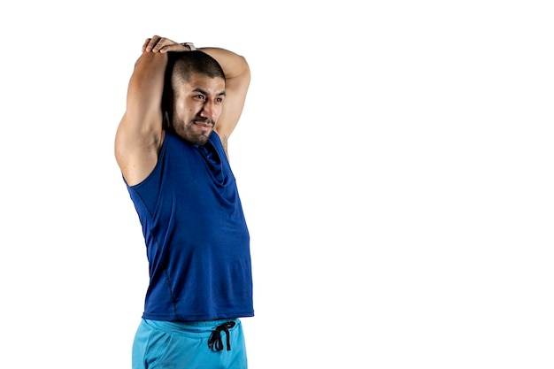 A Latino man does an arm stretch with copy space and a white background