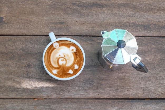 Latte art with moka pot on wood background