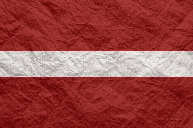 Latvia flag on old crumpled craft paper Textured background wallpaper for design