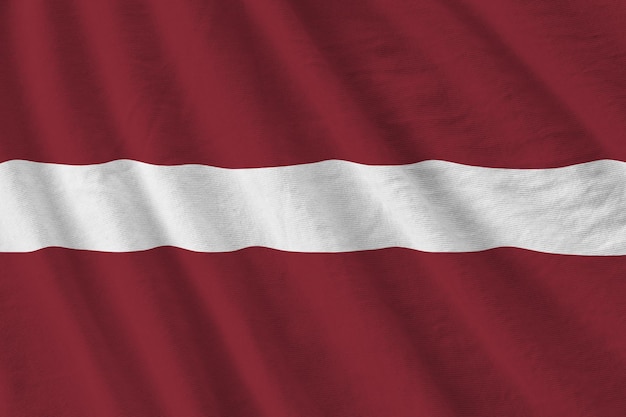 Latvia flag with big folds waving close up under the studio light indoors The official symbols and colors in banner