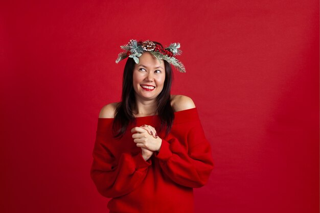 Laughing Asian young woman in ecstasy clasps her hands to her chest