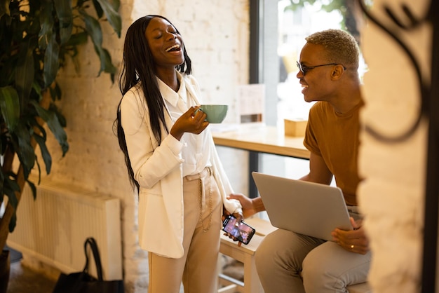 Laughing businesswoman and businessman having break in cafe or restaurant