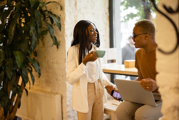 Laughing businesswoman and businessman having break in cafe or restaurant