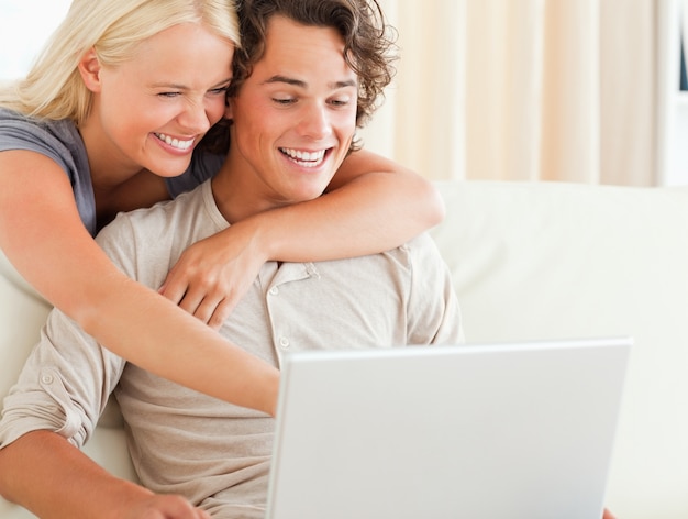 Laughing couple using a laptop