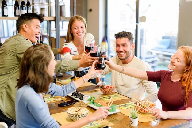 Laughing diverse friends clinking wineglasses