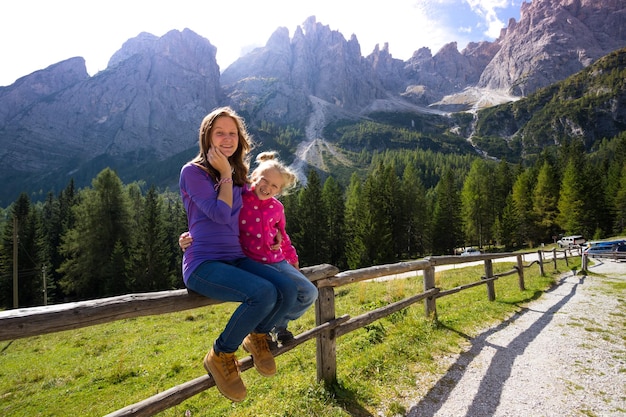 Laughing girls sisters hikers at the mountains Dolomites, Italy. rifugio Lunelli