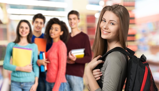 Laughing mexican female student with group of students at library of university            - Image