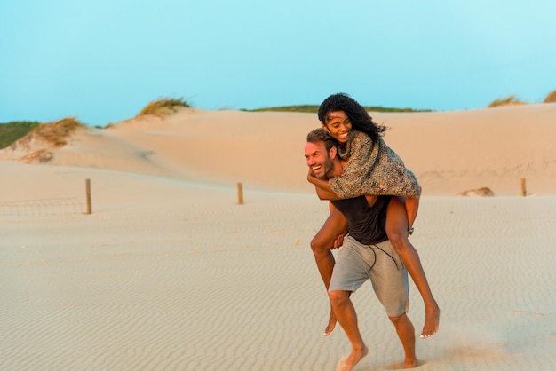 Laughing at piggyback having fun at beach