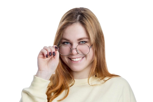 Laughing redhaired young girl in glasses and a yellow sweater Health and confidence Isolated on white background Closeup