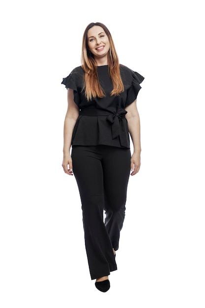 Laughing woman in a suit walks. Beautiful brunette in black trousers and a blouse. Business success. Isolated on white background. Vertical. Full height.