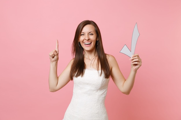 Laughing woman in white dress pointing index finger up, holding check mark