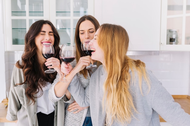 Laughing women drinking wine