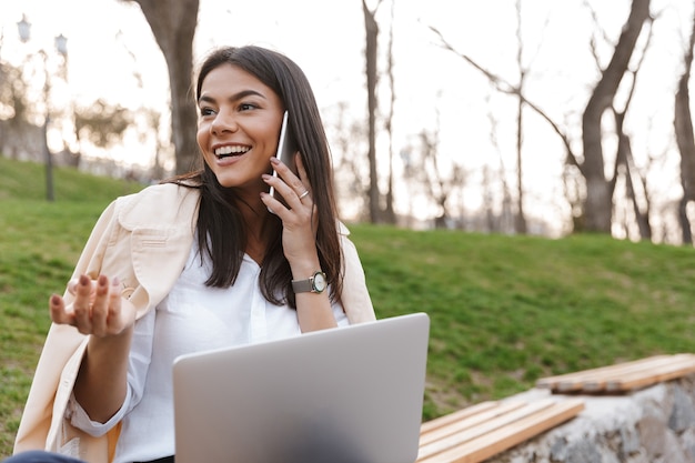 Laughing young woman talking on mobile phone