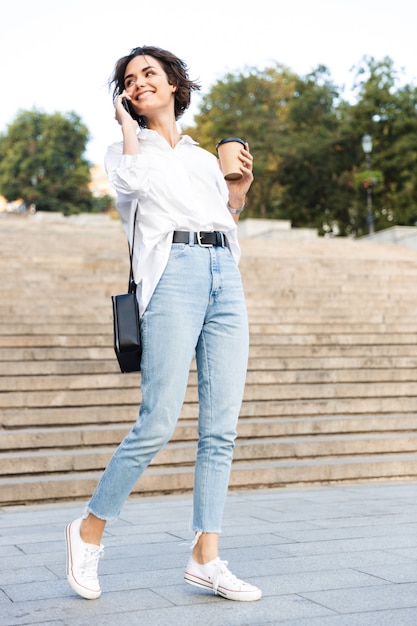 Laughing young woman walking downstairs at the street