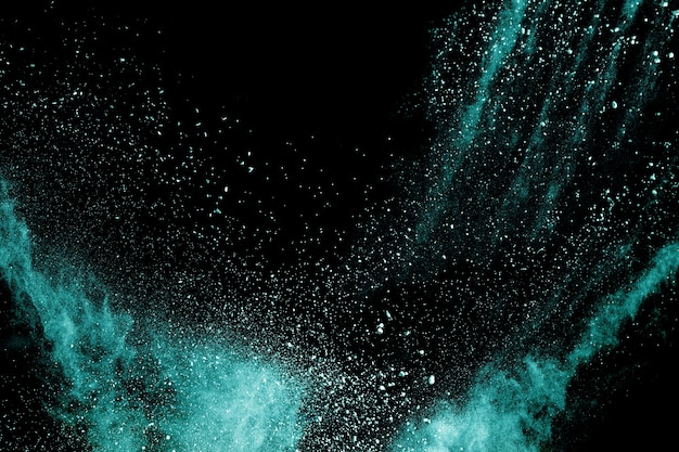 Launched green color powder explosion on black background. 