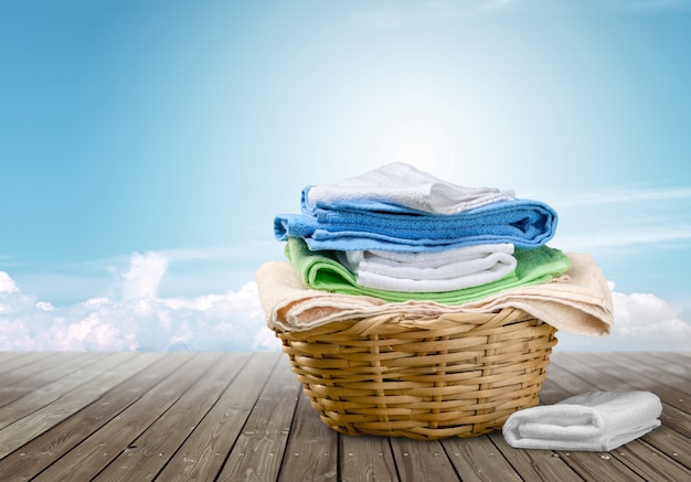 Laundry Basket with colorful towels on background