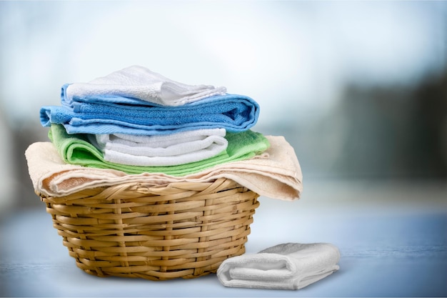 Laundry Basket with colorful towels on background