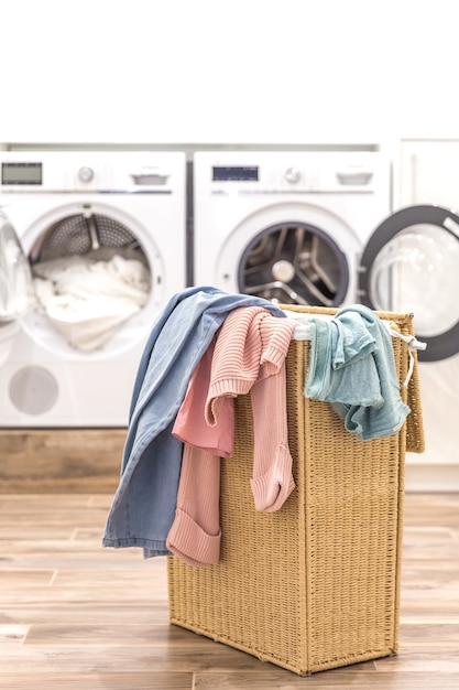 Laundry room with basket and washing and drying machines on background