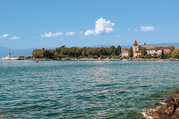 Lausanne, Switzerland - August 26, 2018: Chateau Ouchy at Lake Geneva promenade of Lausanne, Switzerland. People on the background