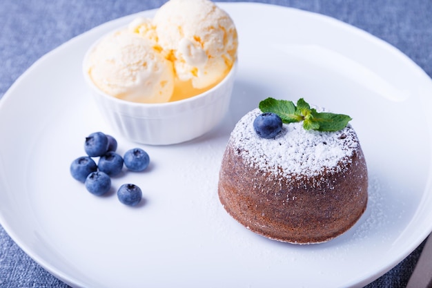 Lava cake chocolate fondant cake with vanilla ice cream blueberries and mint Traditional French pastries Closeup