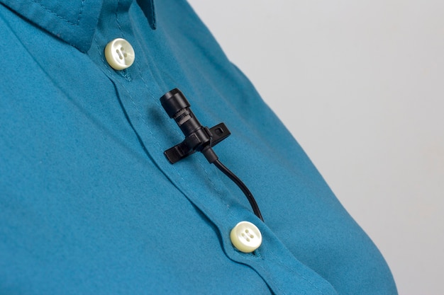 lavalier microphone is secured with a clip on a women's shirt close-up.