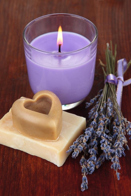 Lavender candle with fresh lavender soap on wooden background