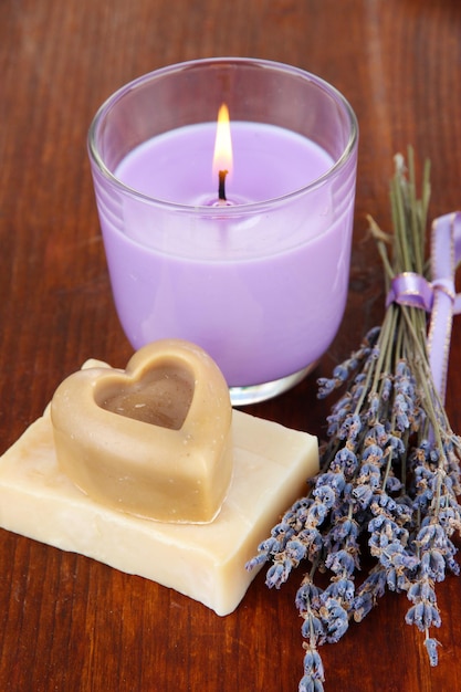 Lavender candle with fresh lavender soap on wooden background