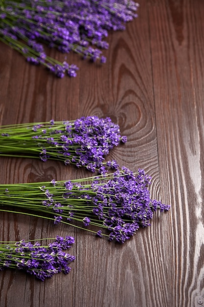 Lavender flowers bunches on brown wooden table flat lay