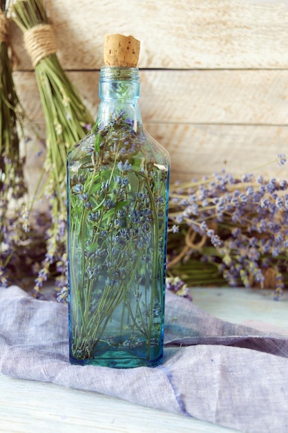 Photo lavender flowers tincture bottles and lavender oil jars on wooden background natural ingredients