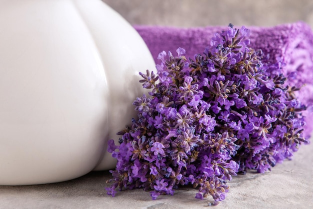 Lavender flowers and towels Concept for spa beauty and health salon cosmetics store Close up photo on marble background