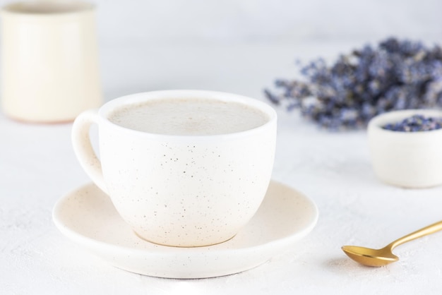 Lavender latte coffee in a mug on a light background.