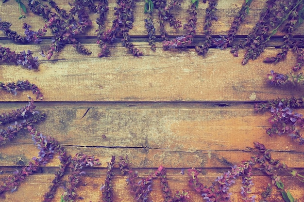 Lavender and sage flowers on a wooden table closeup Horizontal boards of dark old wood with purple and blue flowers and leaves all around Still life and flat lay Free space for text Copy space