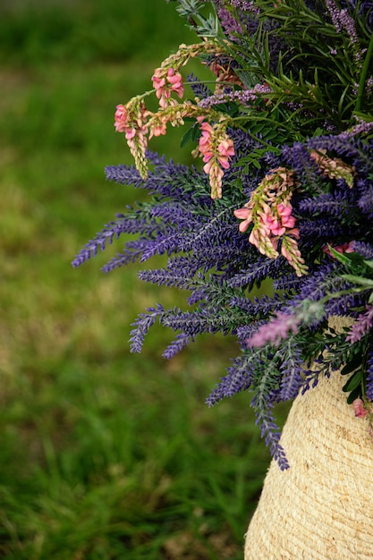 Photo lavender and wild pink flowers in the wicker basketvertical photosummer decoration concept