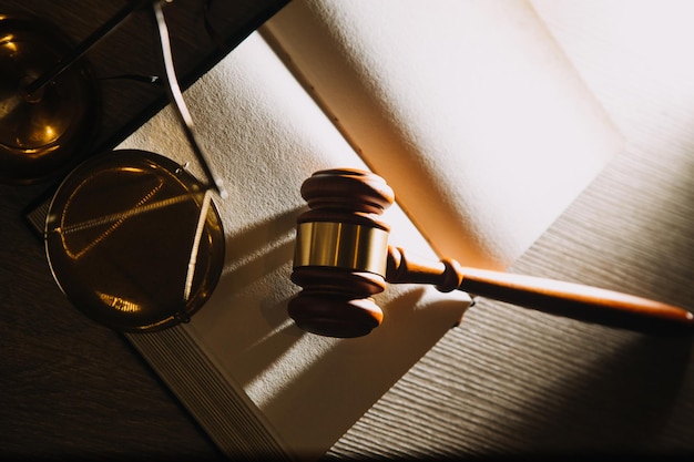 Law books and scales of justice on desk in library of law firm jurisprudence legal education concept