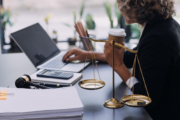 Law books and scales of justice on desk in library of law firm jurisprudence legal education concept