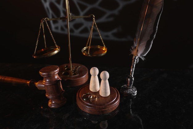 Law and Justice Vertical image of judge gavel wooden figures and wedding rings