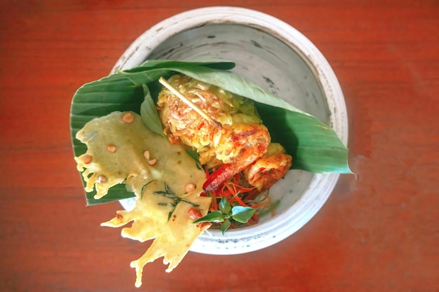 lawar gedang udang traditional cuisine from Indonesia with brown wood background