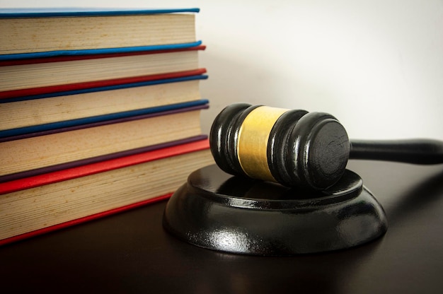 Photo lawyer gavel on wooden table with white and books background