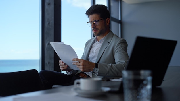 Lawyer reading contract papers at sea view Manager professional at work