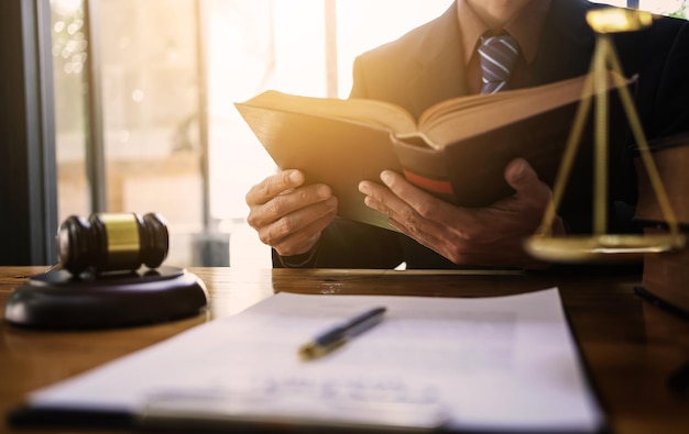 Lawyers read law books while sitting at their desks.