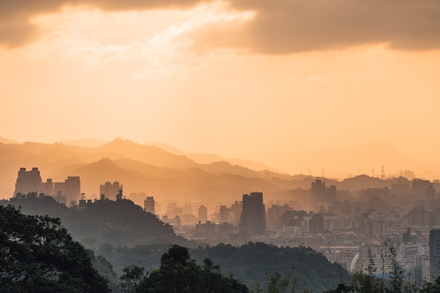 Layers of Taipei cityscape and mountains with sunlight when the sun going down.