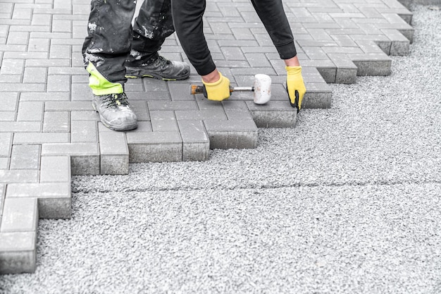 Laying interlocking pavers during the construction of sidewalks and roads