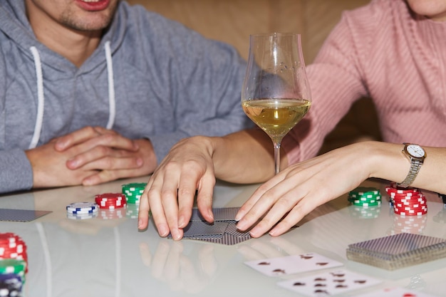 Laying out cards on the table in poker game Players with dices and cards Glass of champagne Gambling concept Candid moment Poker background photography Selective focus